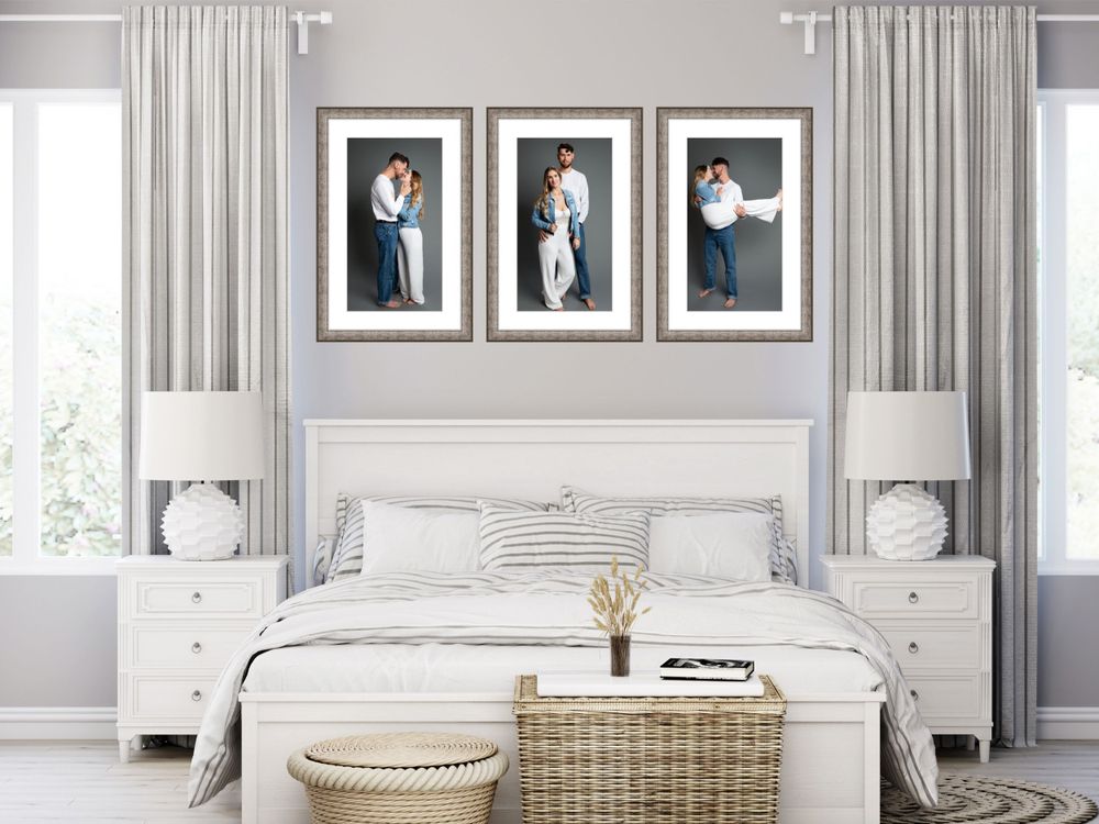 Modern bedroom with three framed black and white photographs above white bed and matching nightstands.