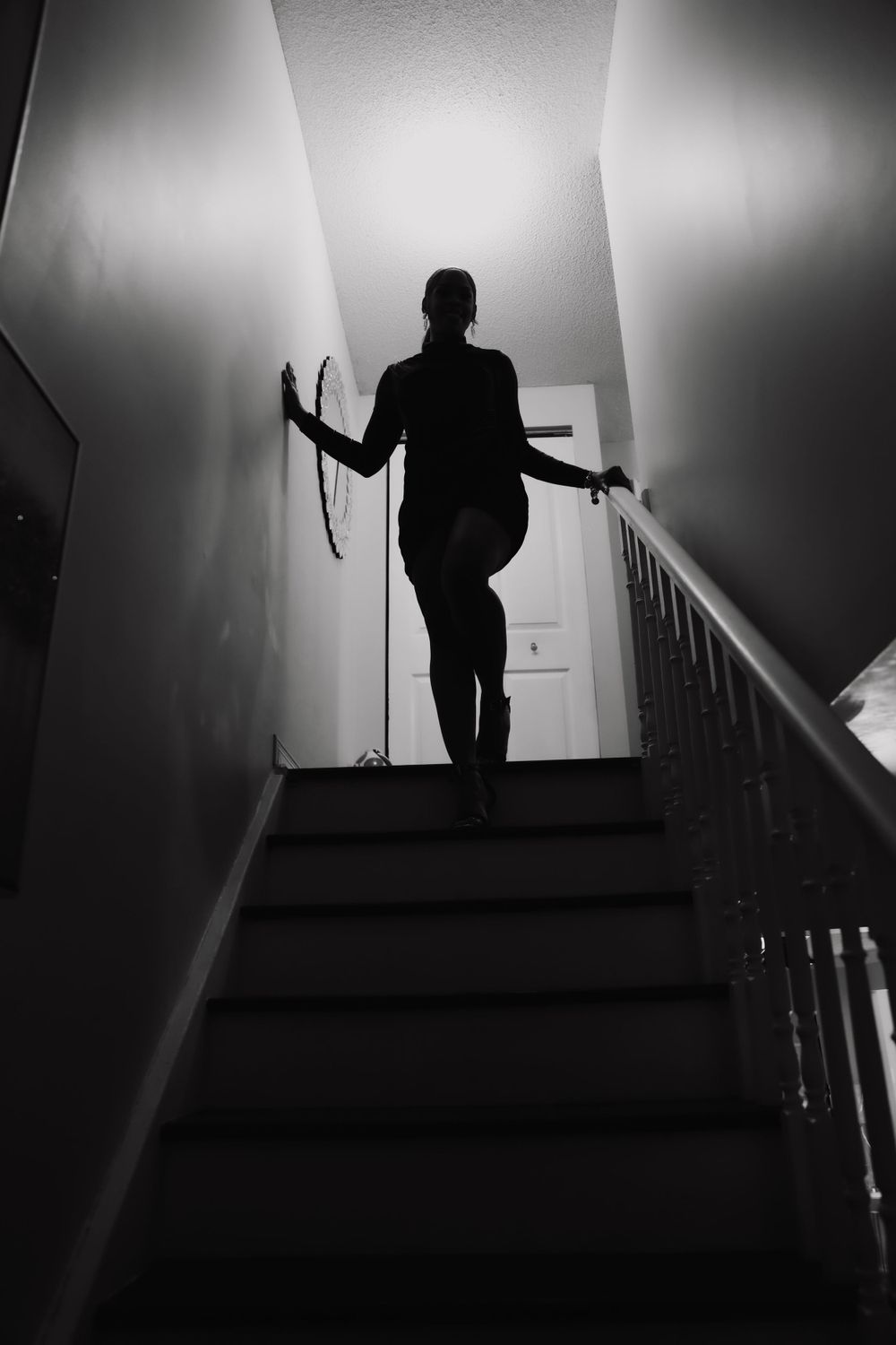 Dramatic silhouette on stairs with moody lighting creating a film noir atmosphere.
