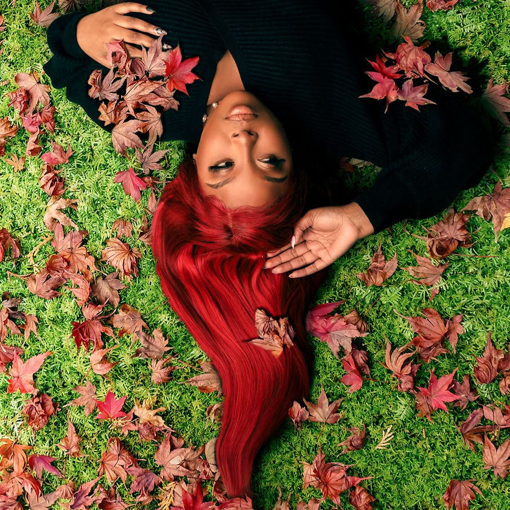 Creative autumn portrait with red maple leaves on green grass.