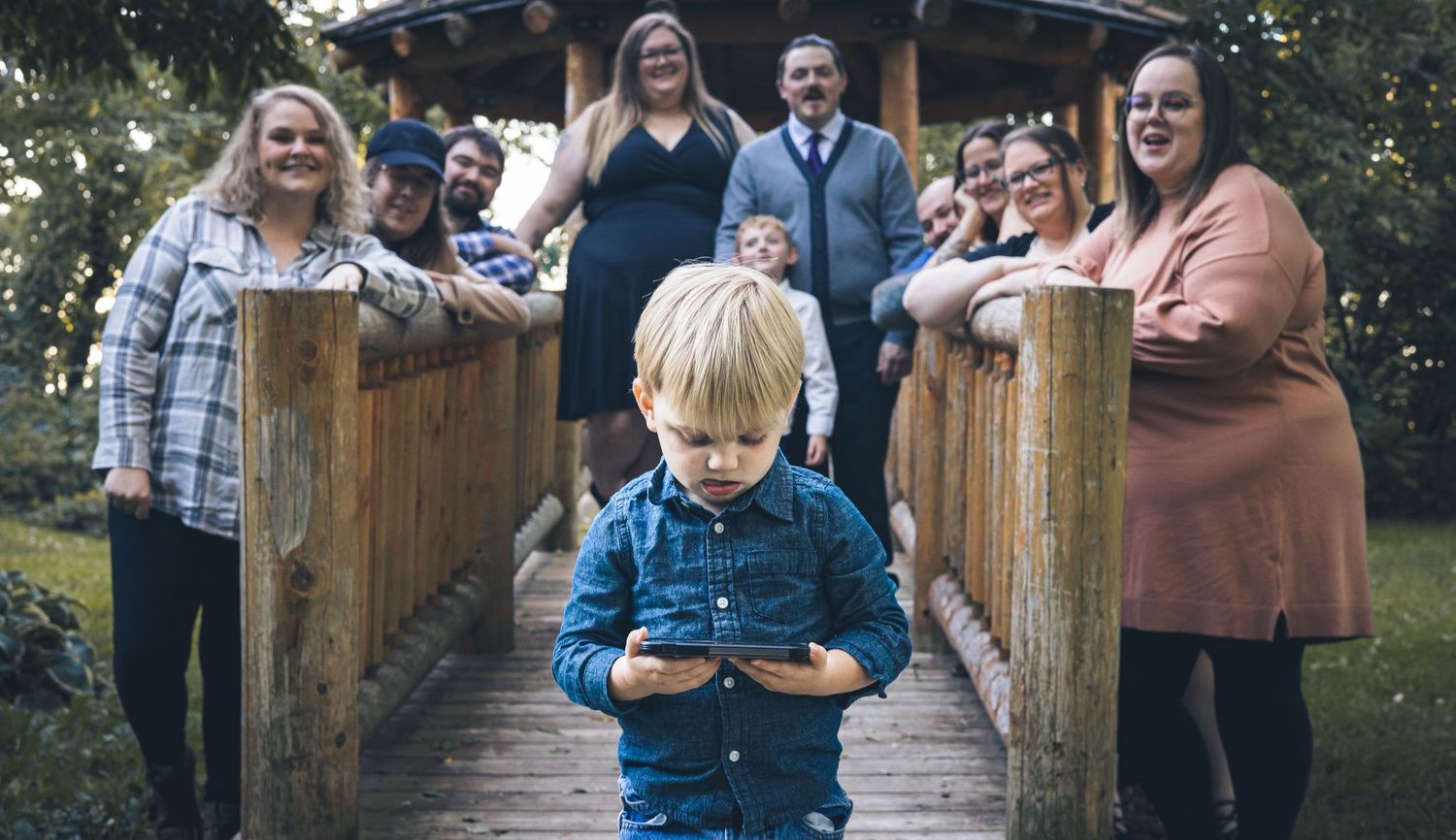 A preoccupied child photobombing a group photo