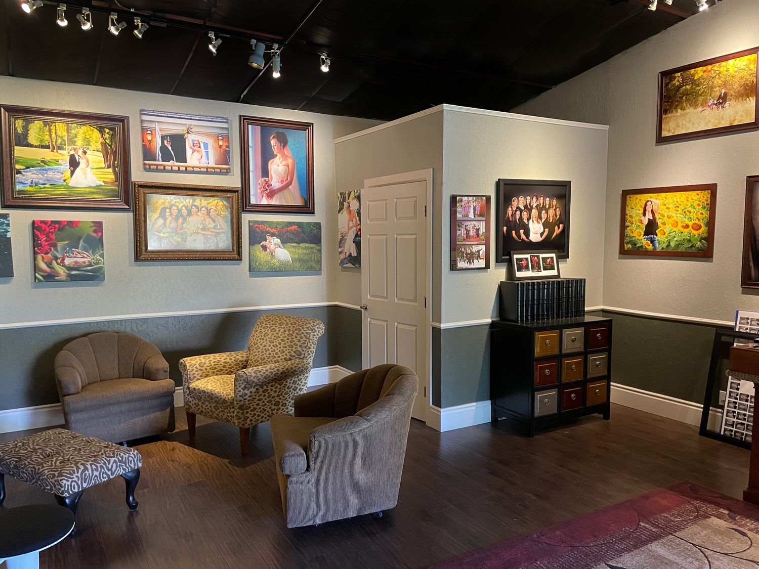Art gallery interior with framed artwork hanging on walls and comfortable seating area.