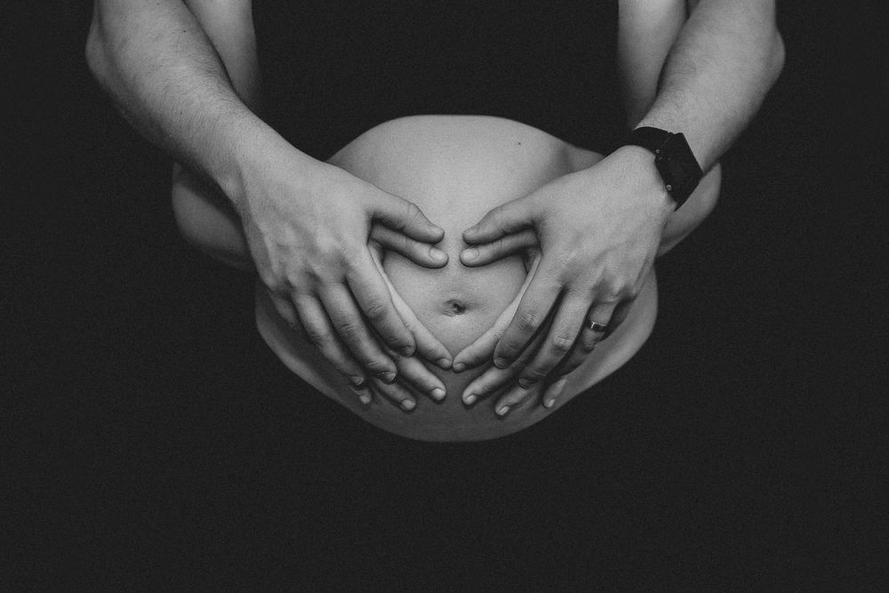 Schwangerschaftsshooting mit Händen auf dem Bauch