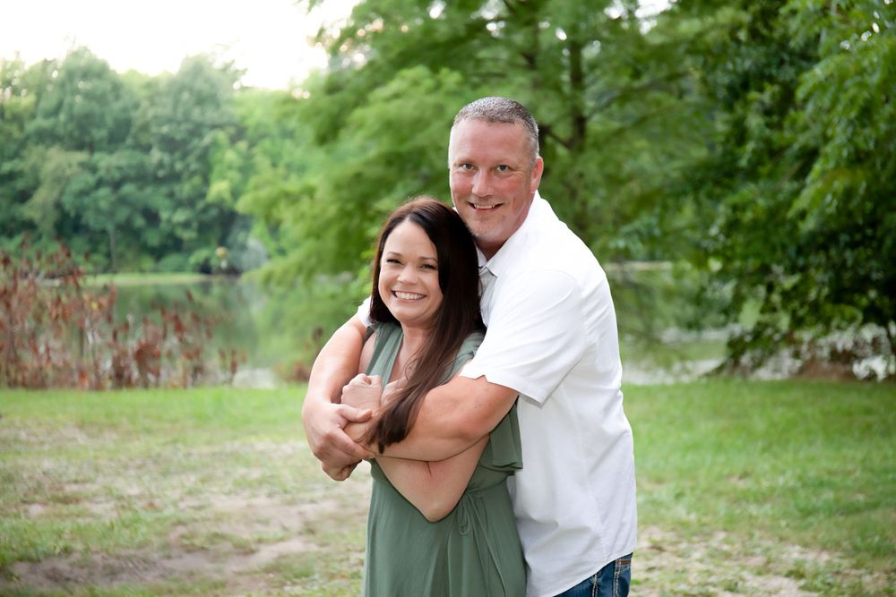A romantic outdoor portrait embracing in a green summer garden setting.