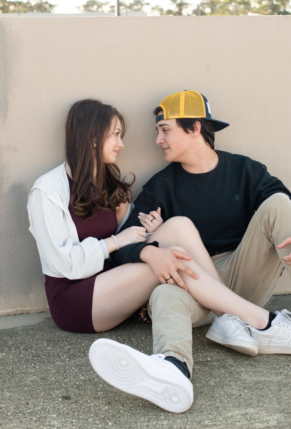 Couple sitting on ground having intimate conversation in urban setting.