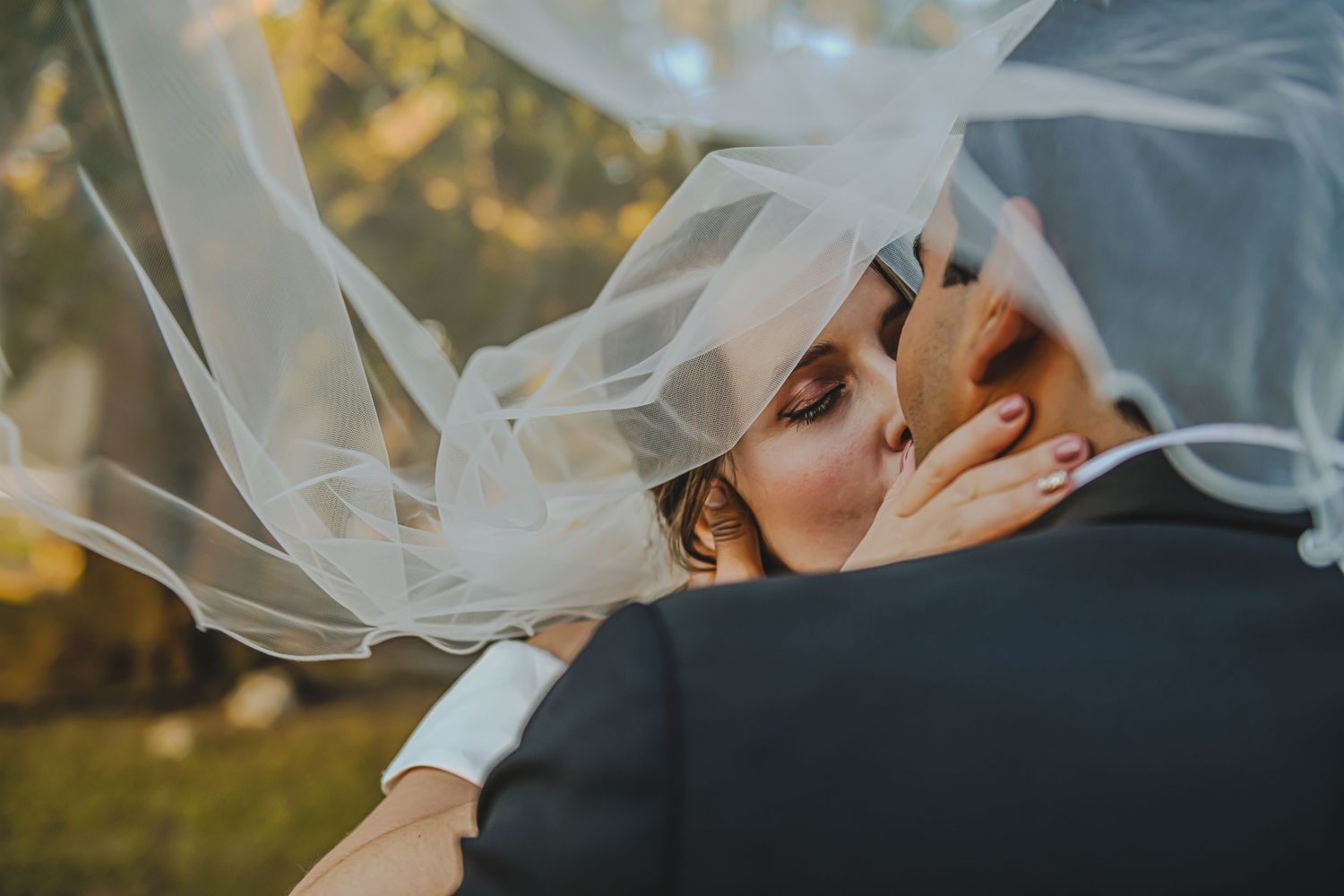 Dramatic Kissing Bride and Groom Outdoor Under Veil