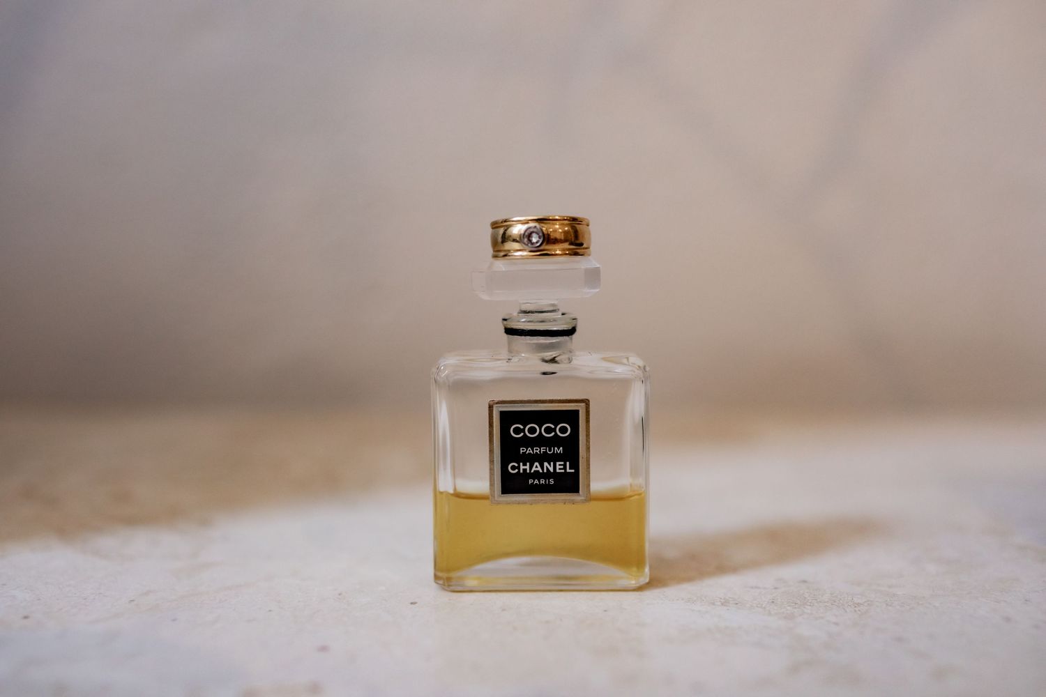 Classic Chanel perfume bottle with golden cap on white surface.