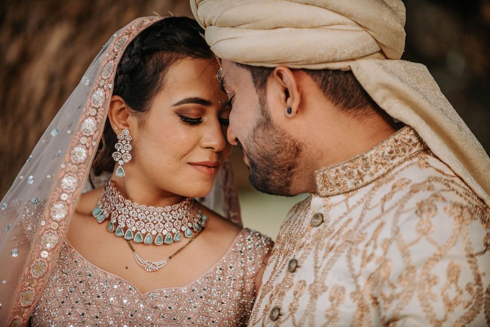 Close-up of couple in ornate South Asian wedding attire sharing an intimate moment.