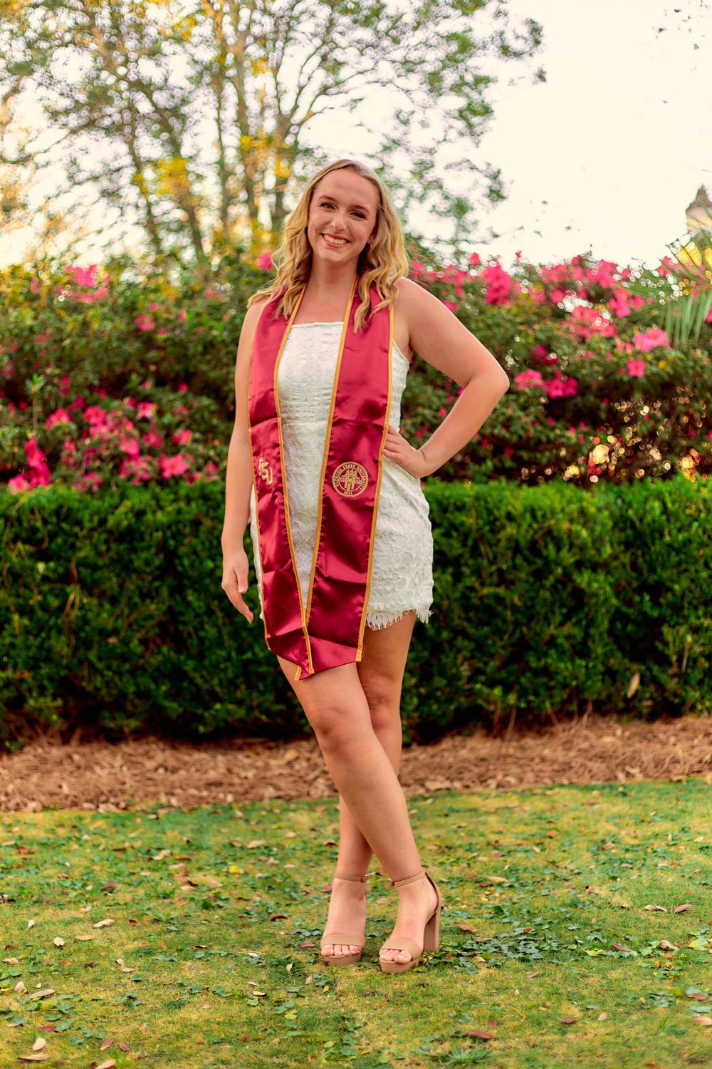 A Graduating woman standing in a garden.