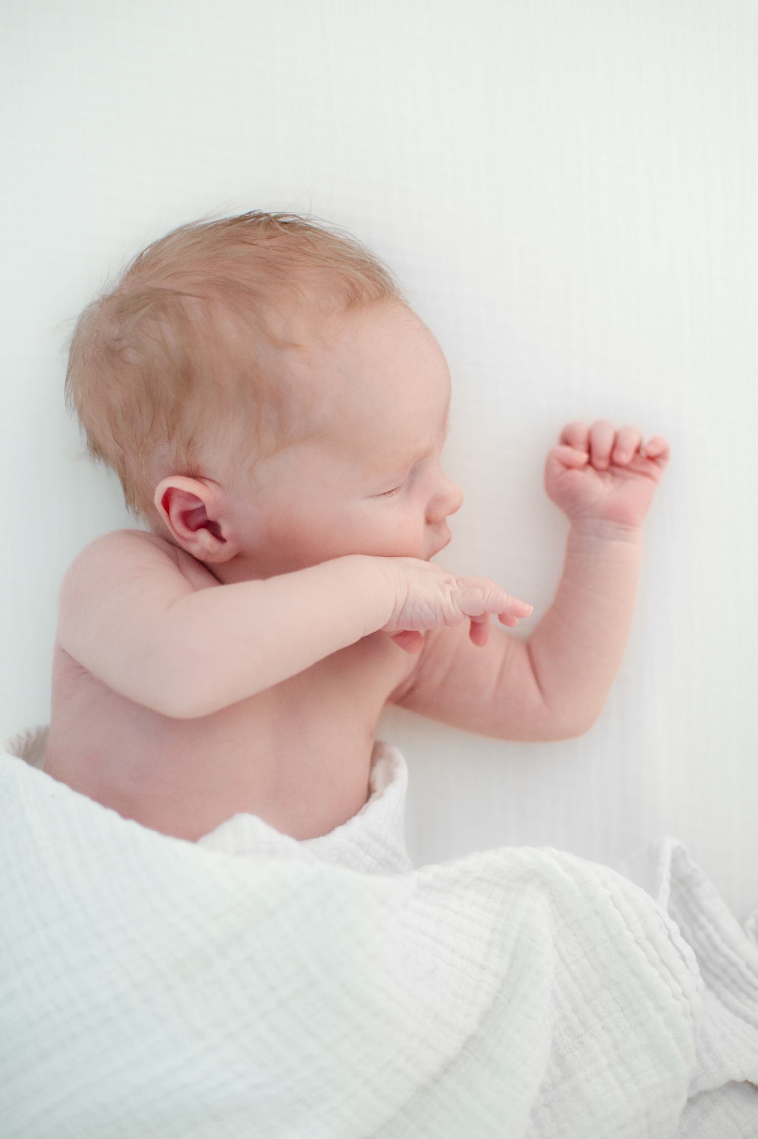 baby sleeping in his crib with swaddle, but naturally posed arms, indianapolis indiana