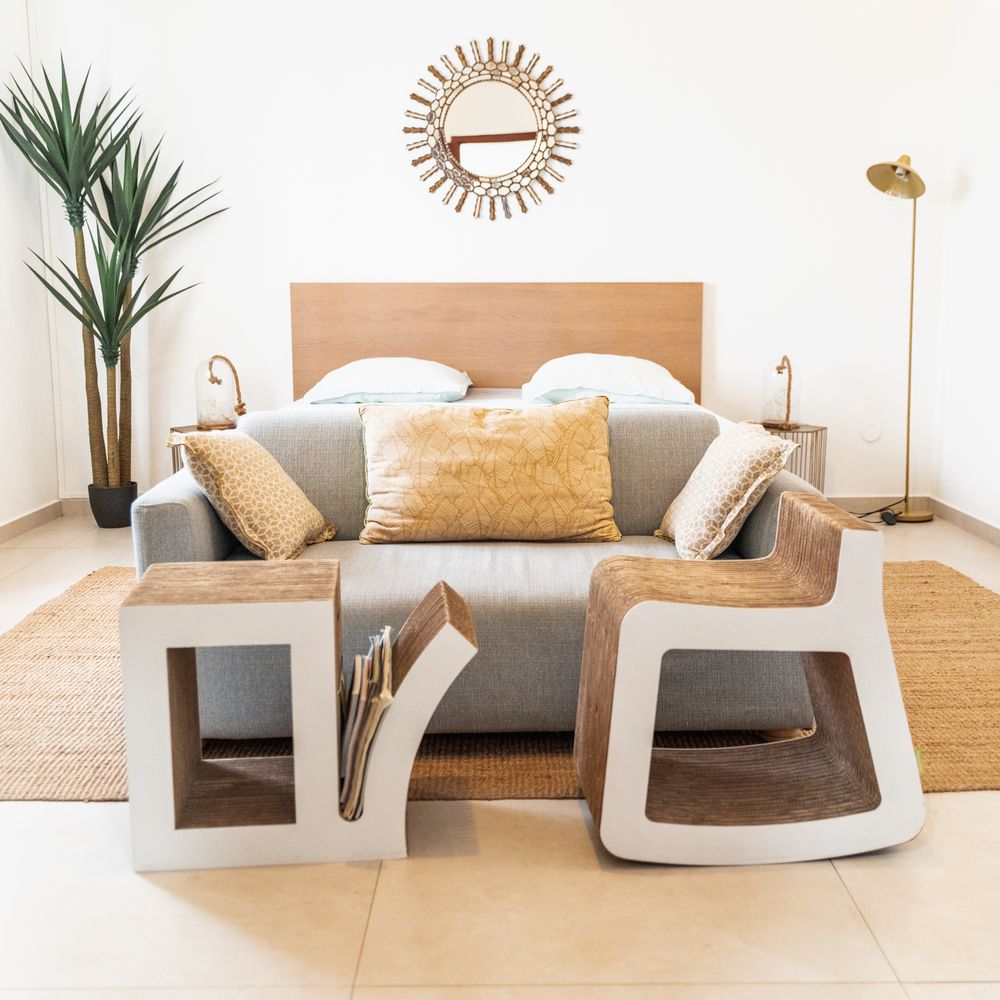 Modern living room with gray sofa, contemporary rocking chairs, and neutral decor.