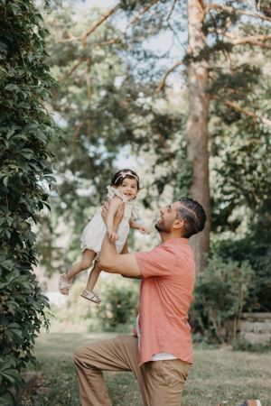Parent and child playing together in a sunlit park setting.