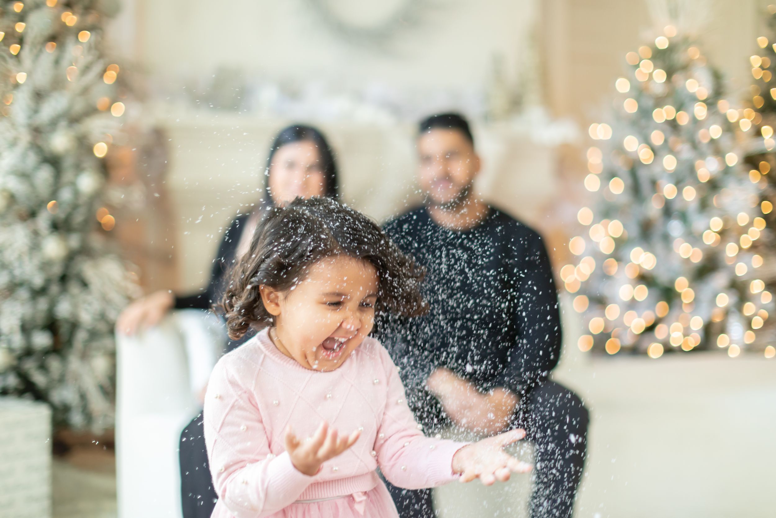 Family enjoying festive moments with sparklers and holiday lights.