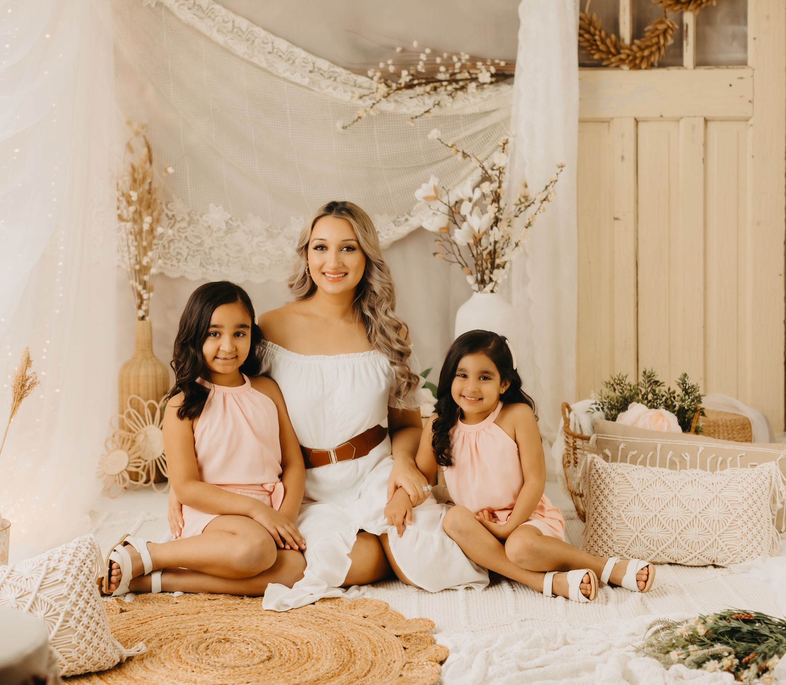 Soft and dreamy maternity photo session in a light-filled studio with neutral tones and floral accents.