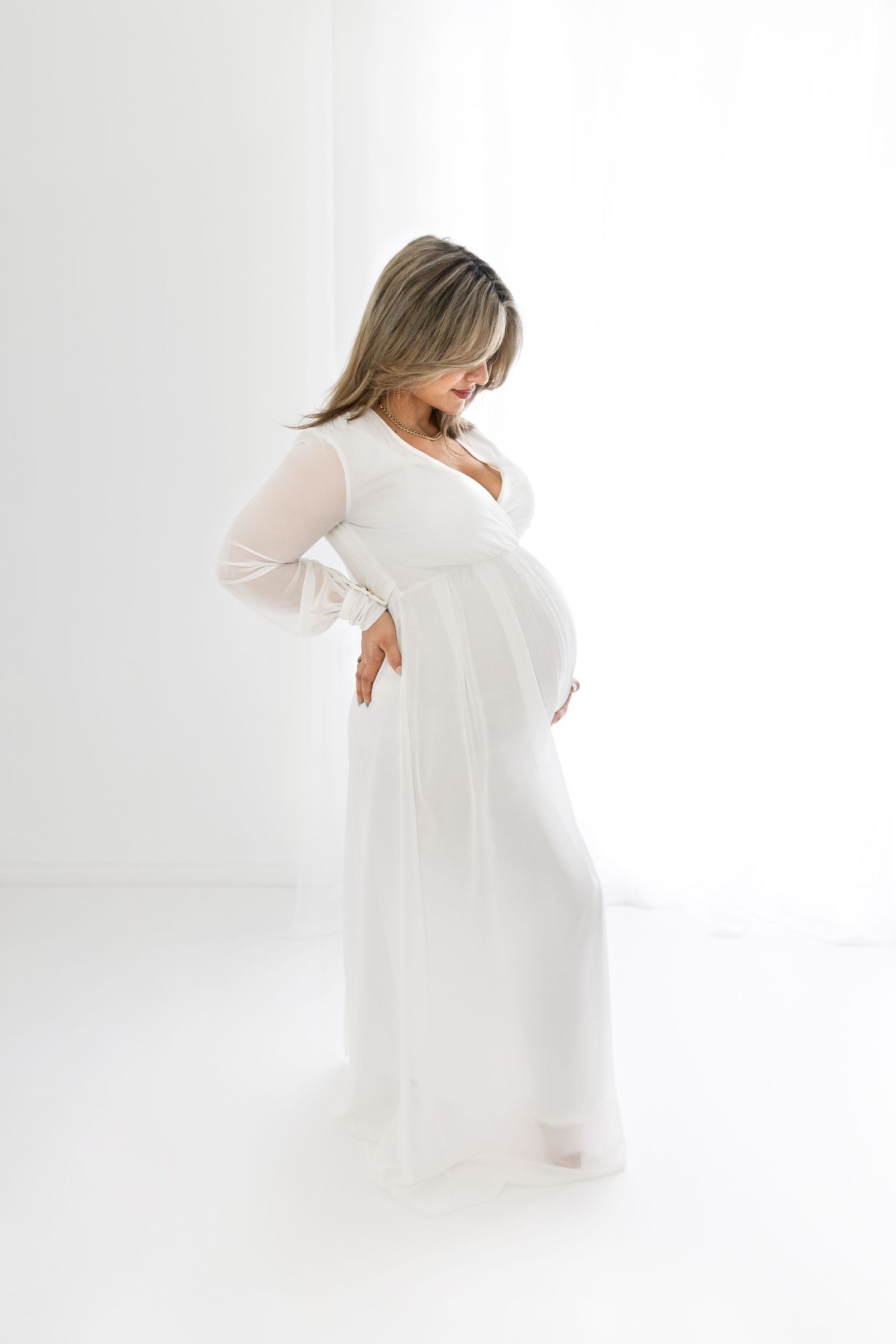 Maternity photo in a white studio & white dress