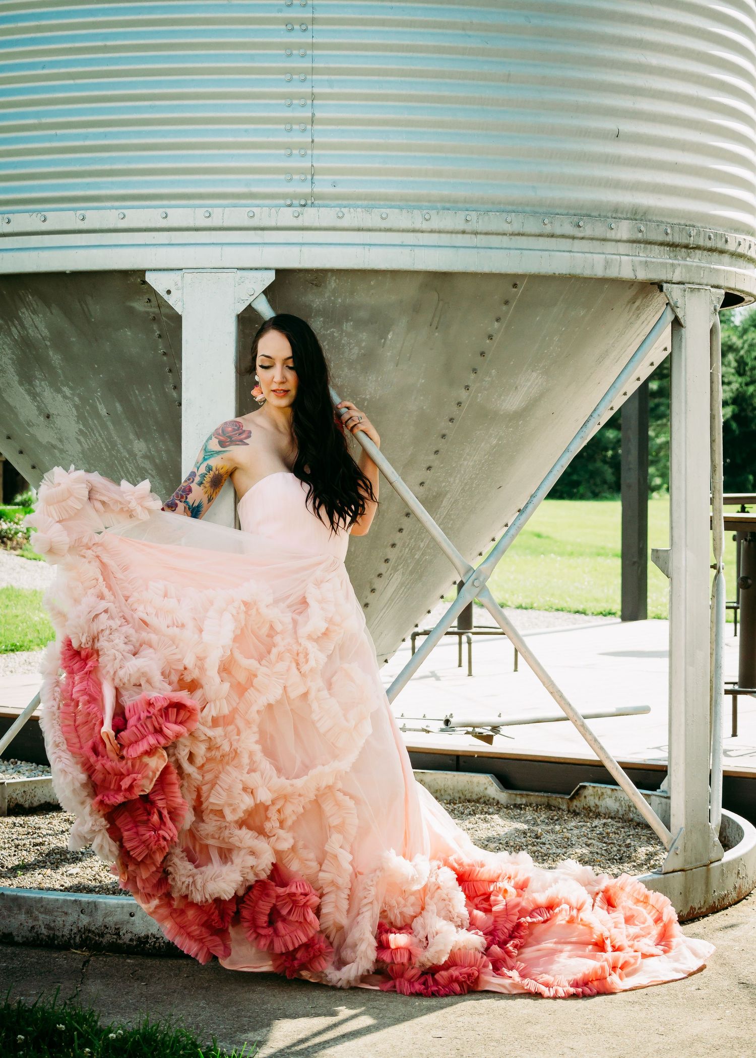Bride tossing the trail of her pink gown