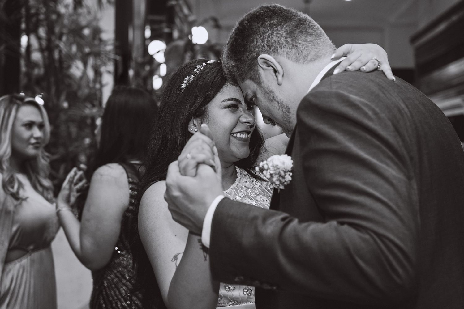 An intimate moment captured in black and white during a wedding celebration.