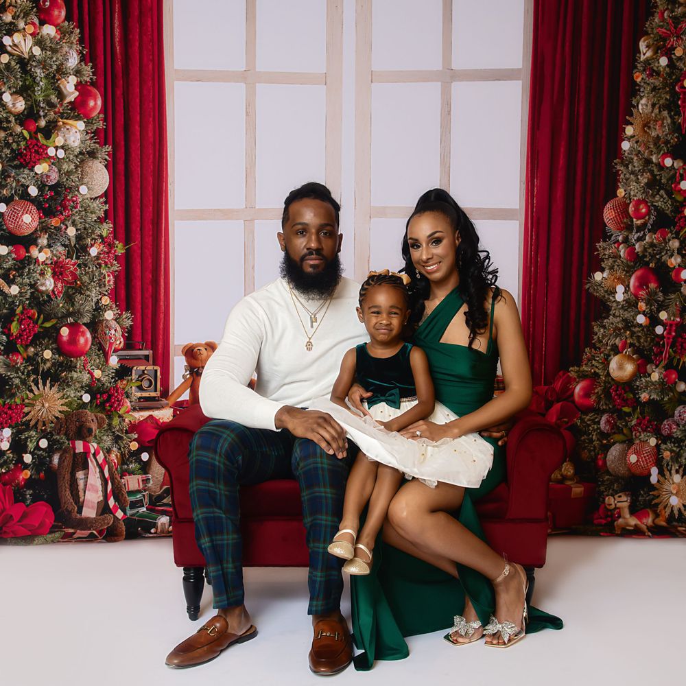 Holiday family photos in coordinated green and white outfits by decorated Christmas tree.