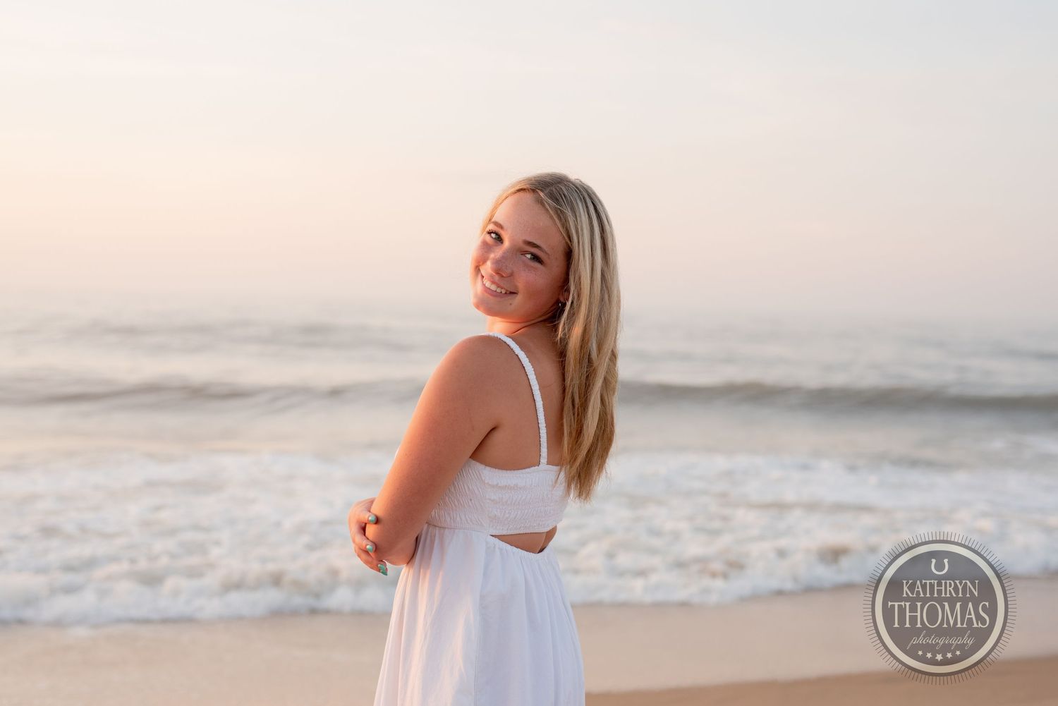 Beachside portrait with waves crashing in the background during sunset.