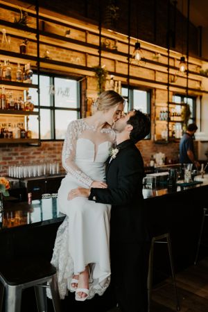 A bride and groom kiss at the bar during their wedding in Northern Colorado
