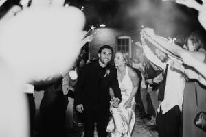 A bride and groom exit their reception through sparklers
