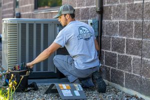 HVAC technician servicing an outdoor air conditioning unit.