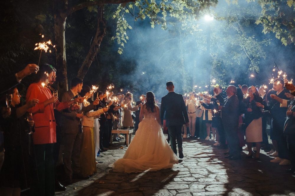 Os convidados do casamento enchem uma passarela com velas de faísca, criando um túnel de saída mágico.