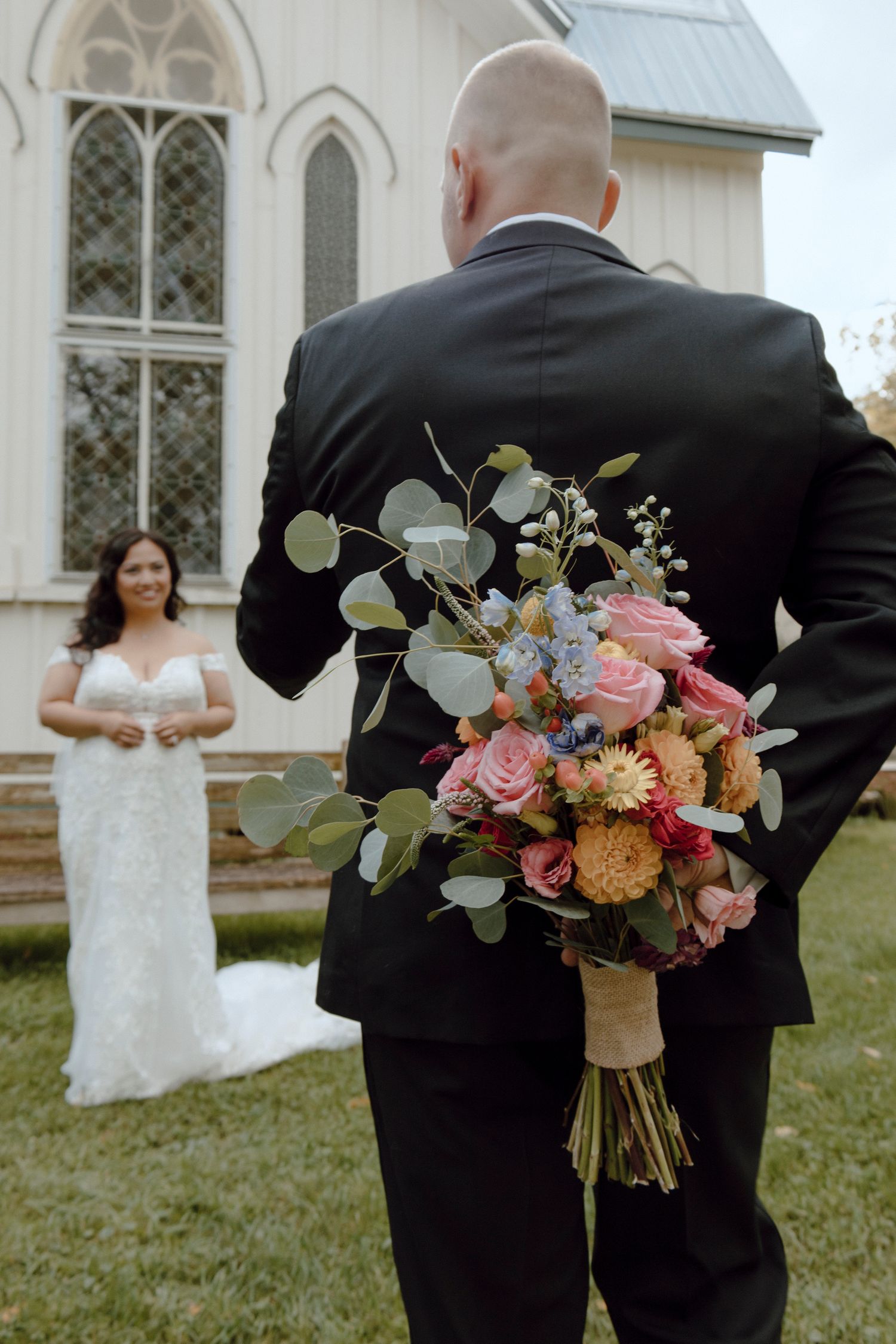 Groom and Bride first look while Groom is holding flowers