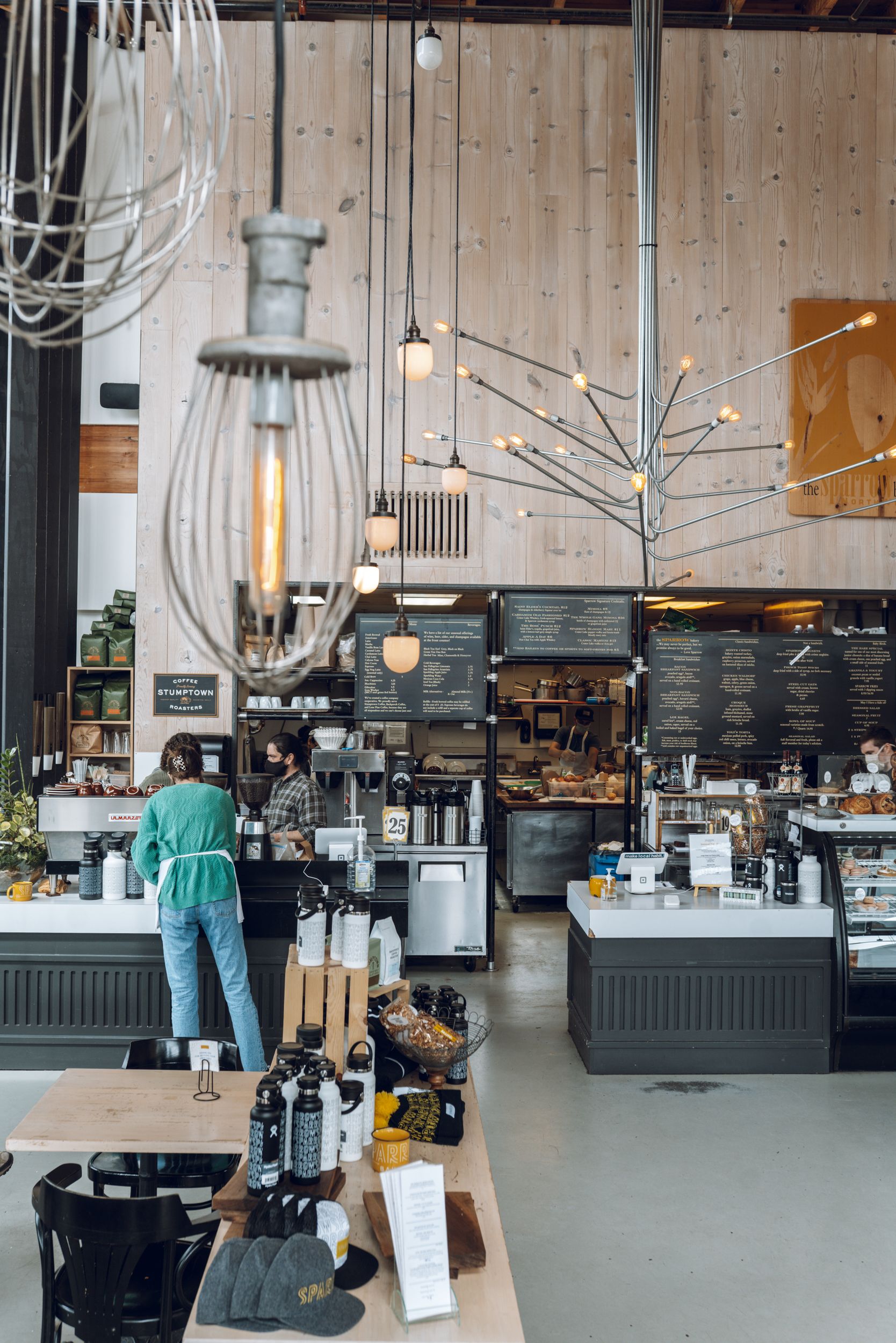 Modern cafe counter with industrial lighting fixtures and minimalist menu boards.
