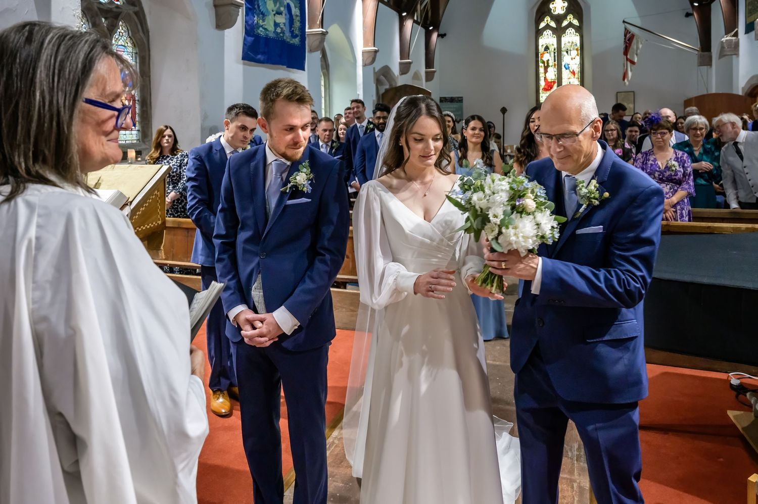 Bride handing bouquet to father at Lake District wedding