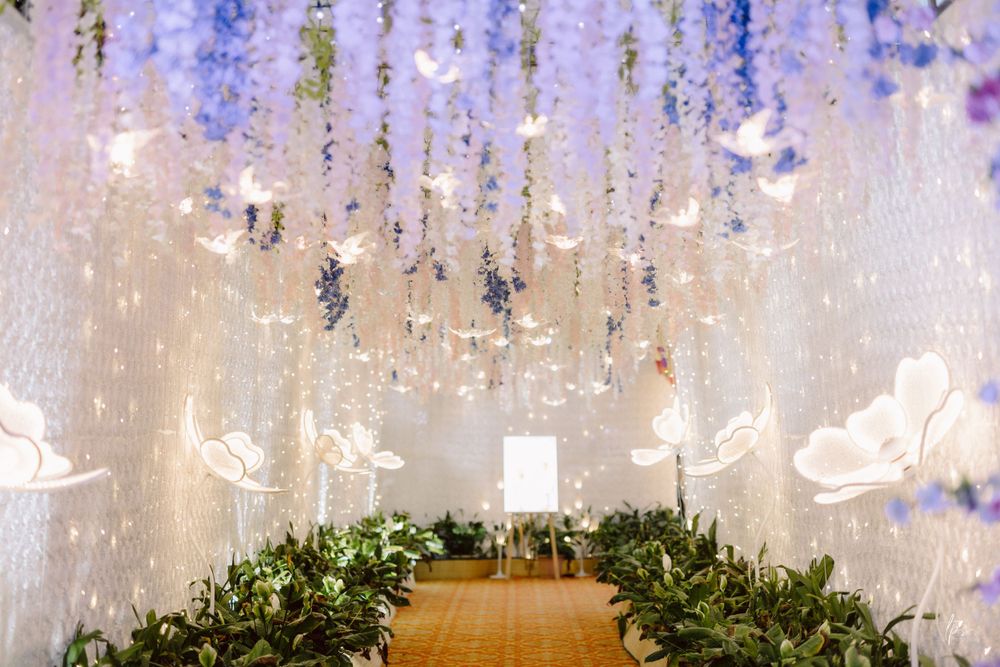 Ethereal wedding venue ceiling adorned with hanging wisteria and crystal decorations.