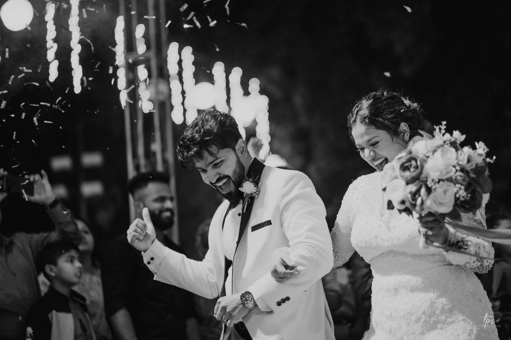 Black and white photo captures joyful moments during wedding reception dancing.