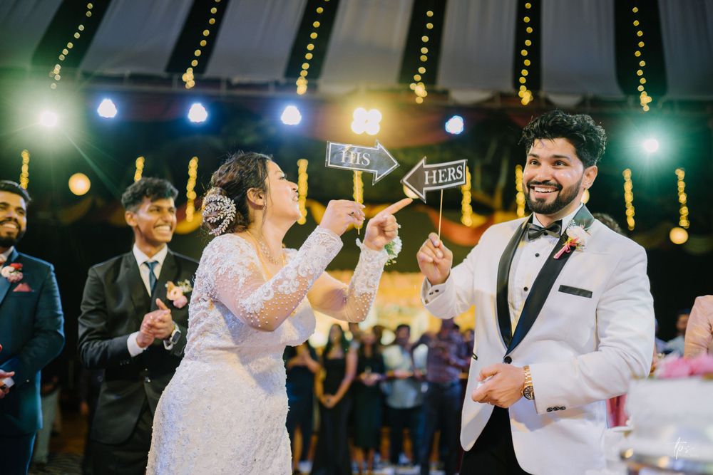 Wedding party celebrates with dancing and drinks under ambient venue lighting.