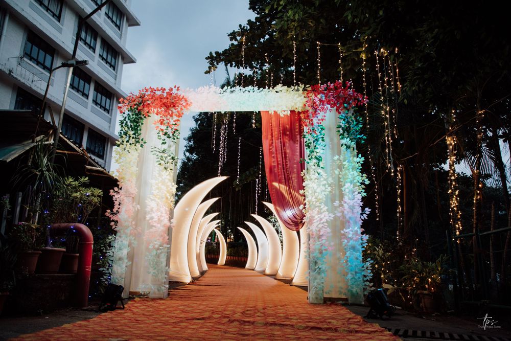 Illuminated wedding entrance pathway with glowing arches and colorful lighting effects.