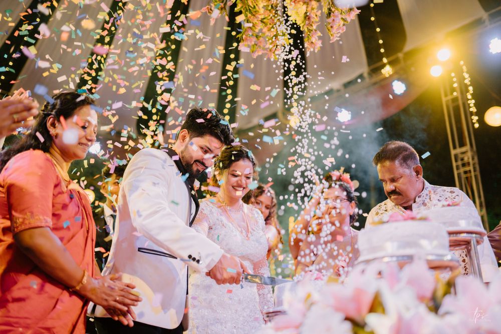 Wedding celebration with confetti and golden lighting creates magical atmosphere.
