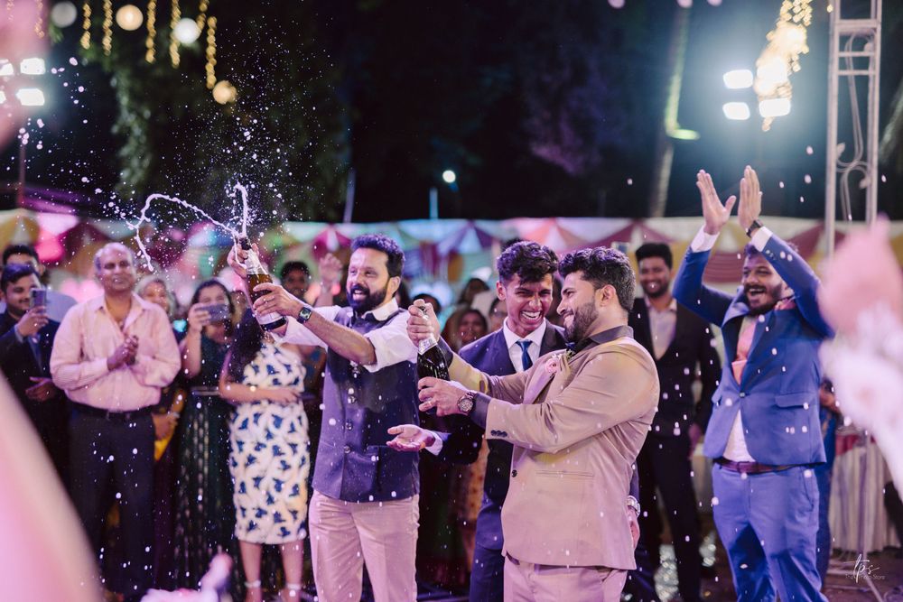 Wedding reception dance floor filled with guests celebrating under colorful lighting and decorations.