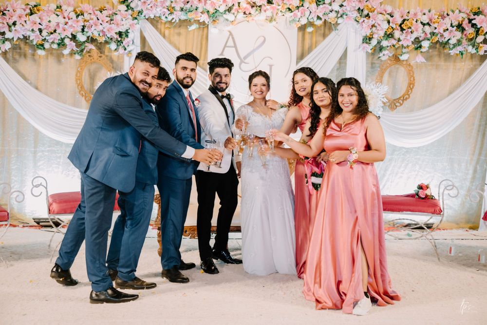 Wedding celebration with bridesmaids in coral dresses and guests mingling at decorated venue.