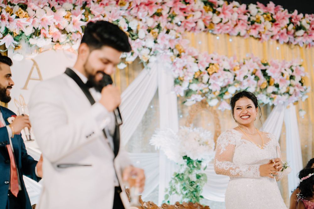 Wedding reception space adorned with cascading pink floral arrangements and soft lighting.