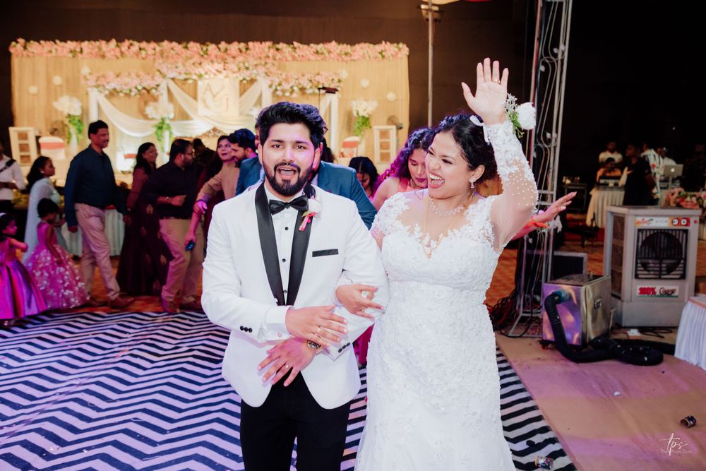 Wedding reception venue with elegant decor and guests celebrating on the dance floor.