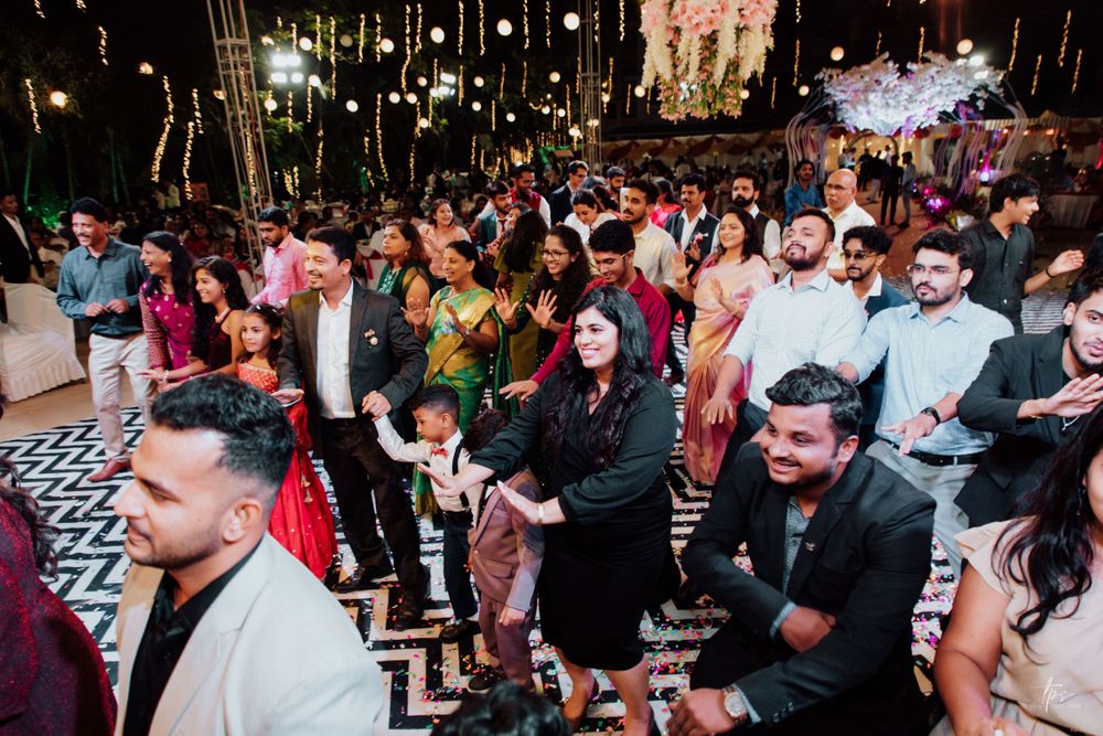 Crowded wedding reception dance floor with guests celebrating under ambient lighting.
