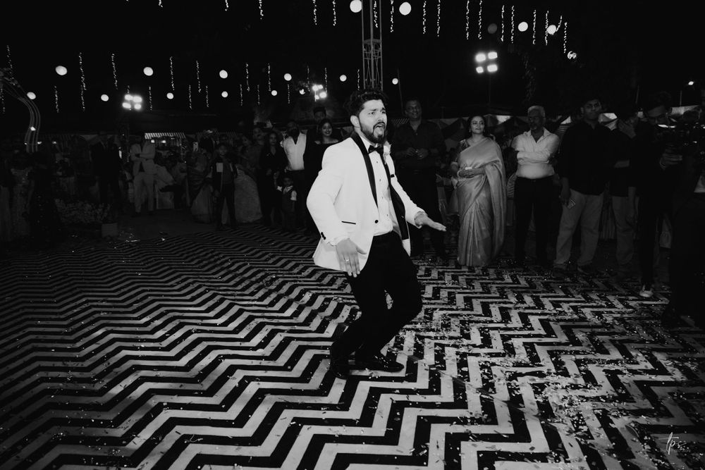 Black and white photo of a geometric patterned dance floor with string lights overhead.