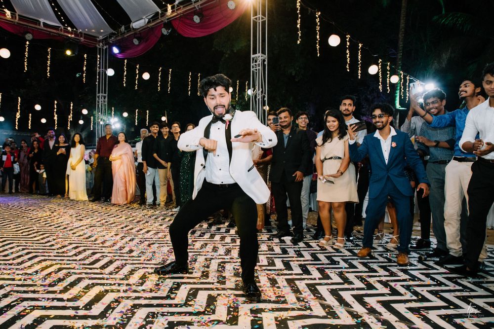 Wedding reception dance floor with black and white geometric pattern surrounded by guests.