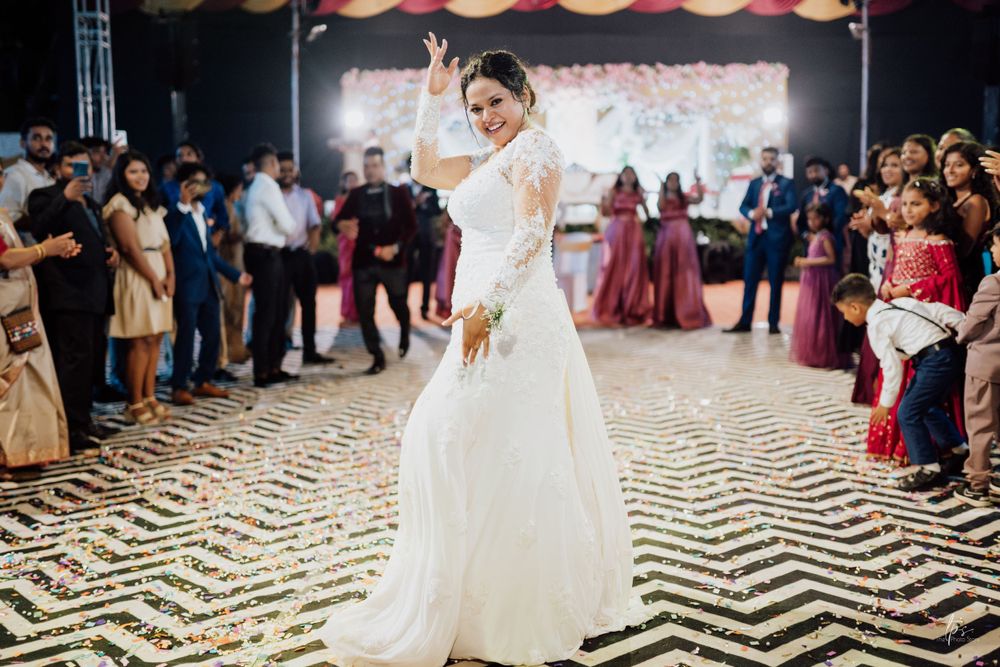 Bride twirls on black and white chevron dance floor during wedding reception celebration.