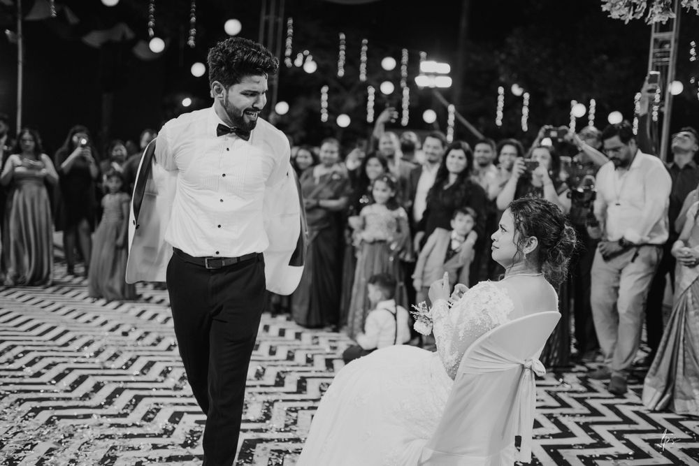 Black and white reception photo showing guests dancing on patterned floor.