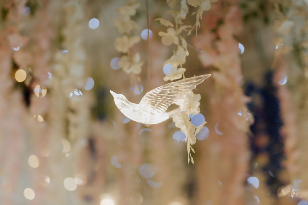 Delicate butterfly and crystal decorations hanging from wedding venue ceiling.