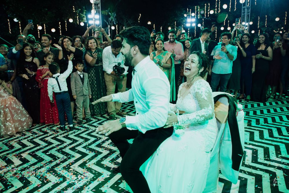 Wedding couple dances energetically on a black and white chevron patterned dance floor.