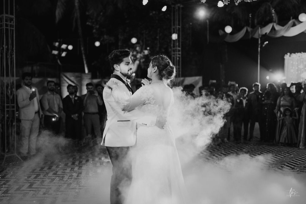 A romantic first dance moment captured in black and white with atmospheric fog effects.