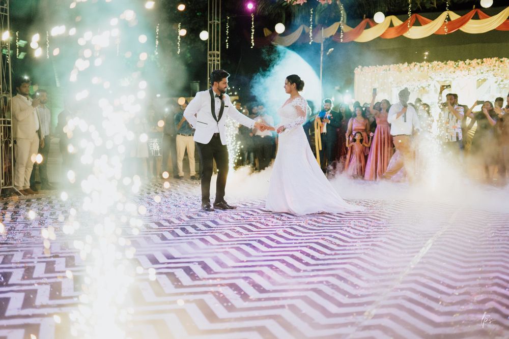 A couple dances on a geometric patterned floor with dramatic fog and lighting effects.