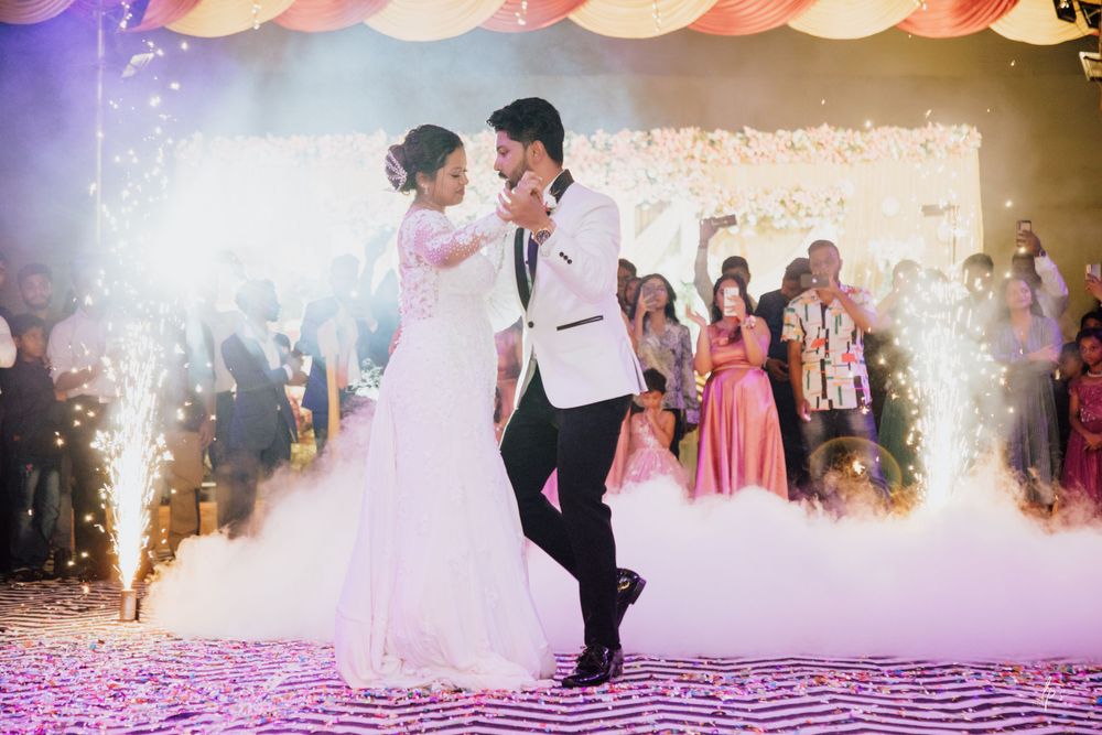 Newlyweds perform their first dance surrounded by dramatic lighting and fog effects.