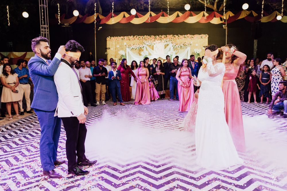 Wedding reception dance floor features a striking black and white chevron pattern with purple lighting and hanging decorations.