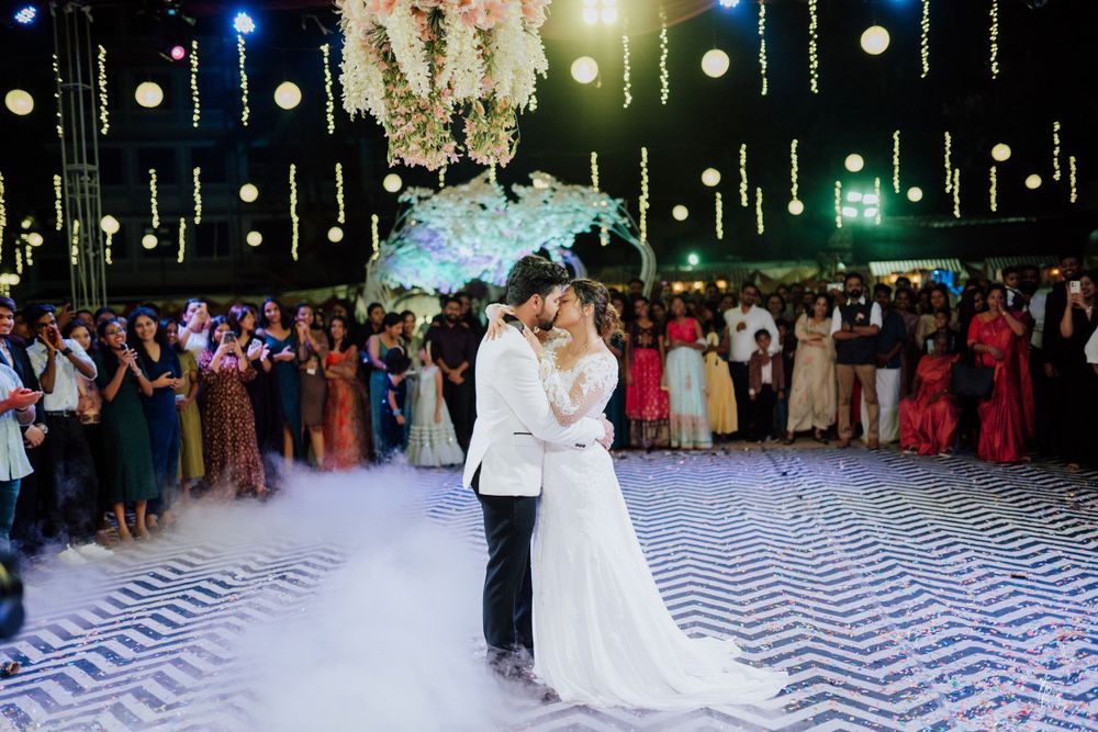 Festive wedding reception scene with dramatic lighting and geometric floor pattern.
